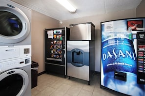 A laundromat with a washing machine, a vending machine, a refrigerator, and a Dasani water dispenser. - Red Roof Inn PLUS+ Nashville South - Fairgrounds (Nashville)