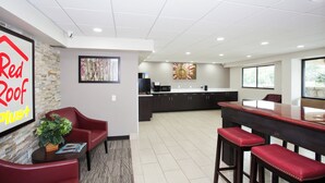 A spacious indoor area with a kitchen, seating area, and a Red Roof sign.