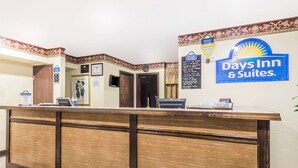 Una recepción con el letrero de Days Inn & Suites, un reloj y un cuadro en la pared.