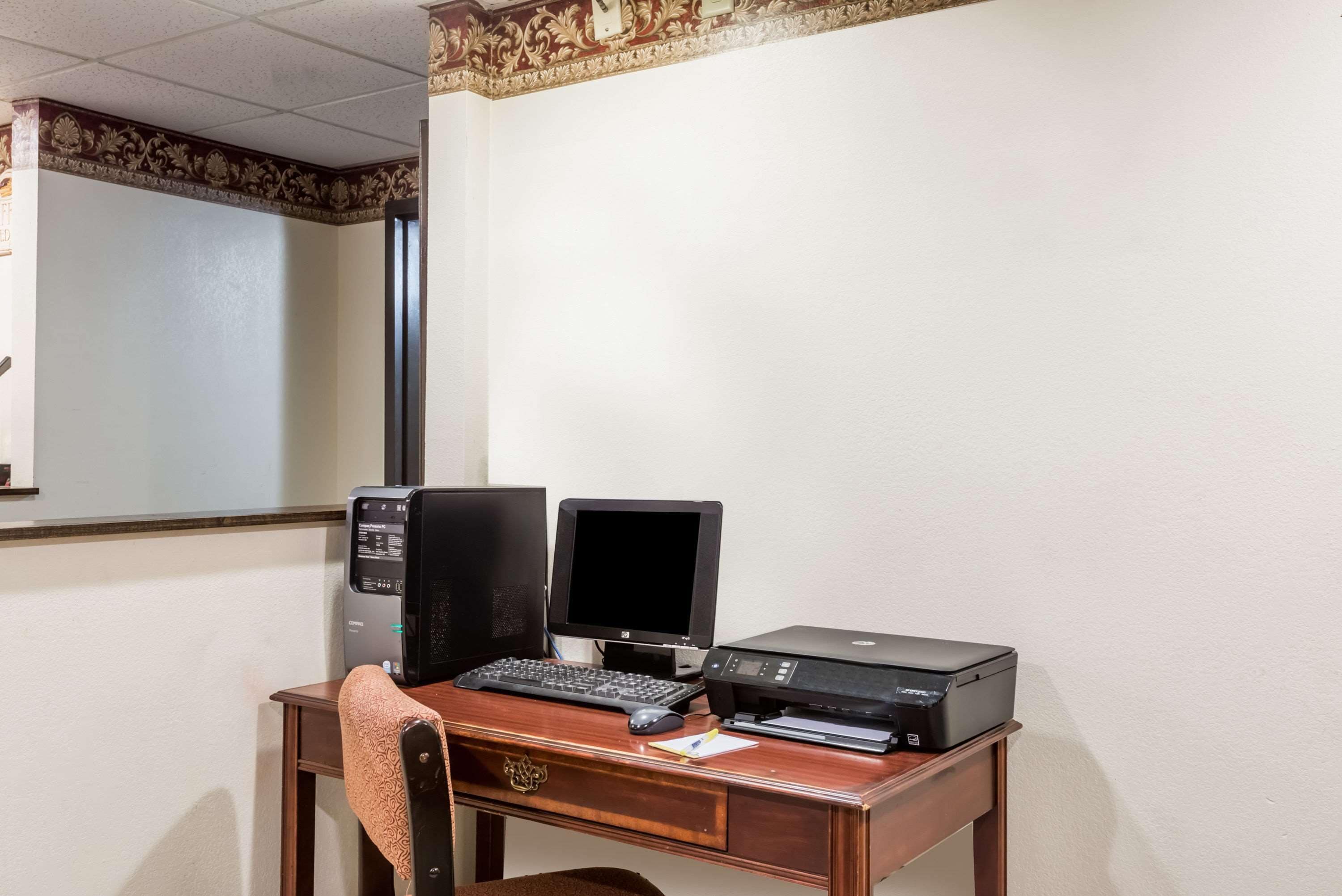 A wooden desk with a desktop computer, a monitor, and a printer.
