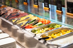 A buffet with various food options, including salads, vegetables, and meats.