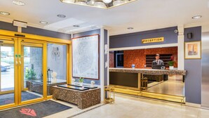 Un espace d’accueil d’hôtel comprenant un comptoir de réception, une grande carte encadrée et un panneau indiquant la réception.
