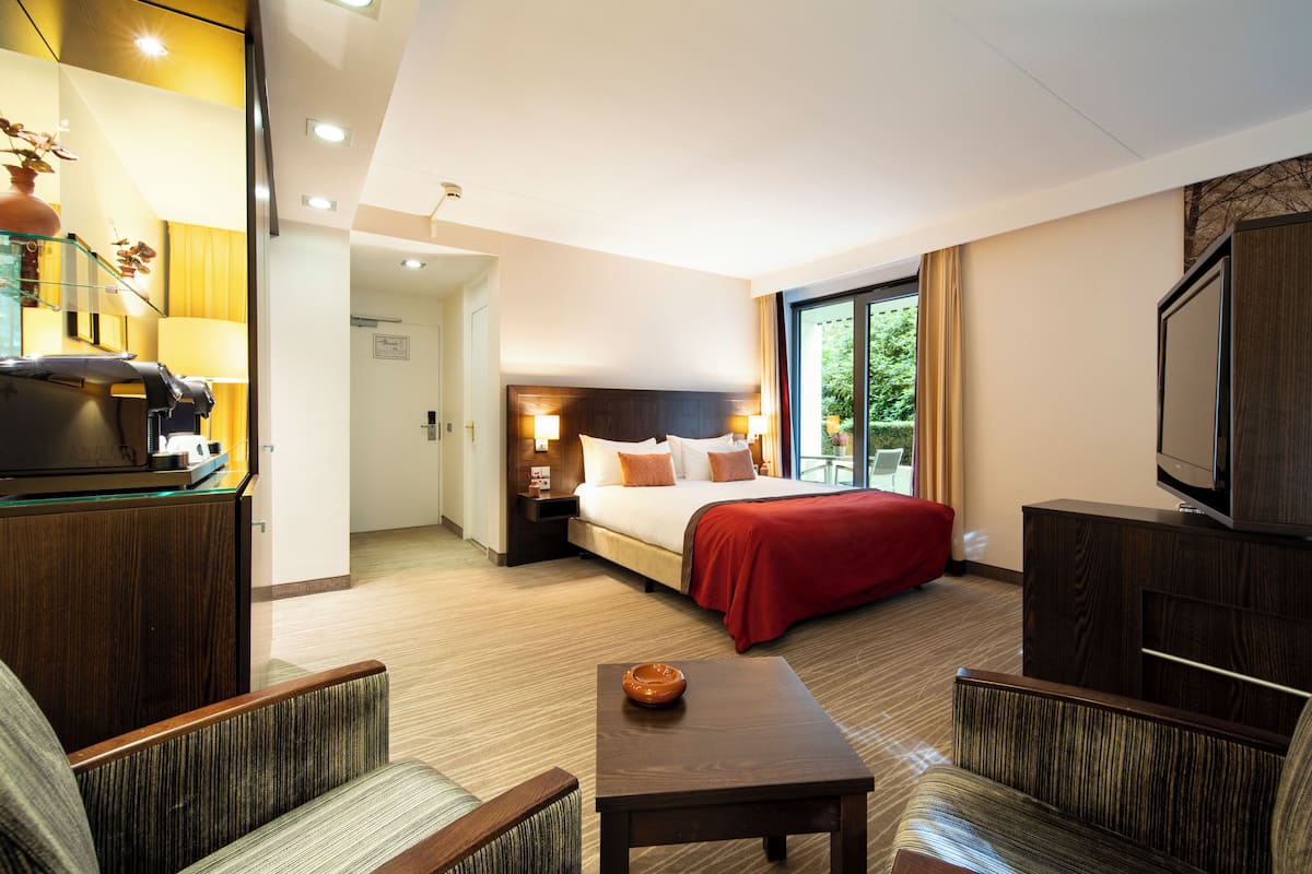Una habitación de hotel con cama, televisión, escritorio y zona de estar.