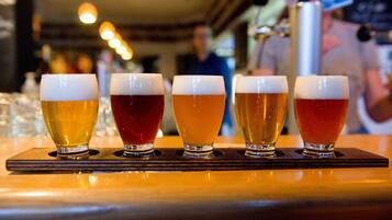 A bar with glasses of beer in a row.
