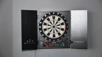 A dartboard mounted on a wall with a digital score display below it.