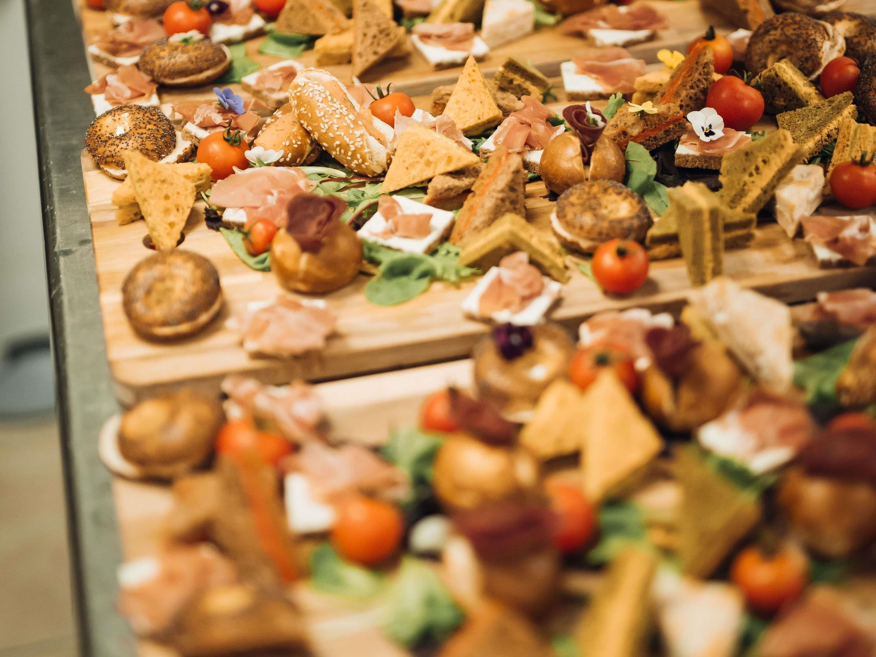 Une variété d’aliments disposés sur des planches en bois, notamment du pain, du fromage et des légumes.