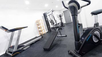 A gym with cardio equipment, weight machines, and a treadmill.