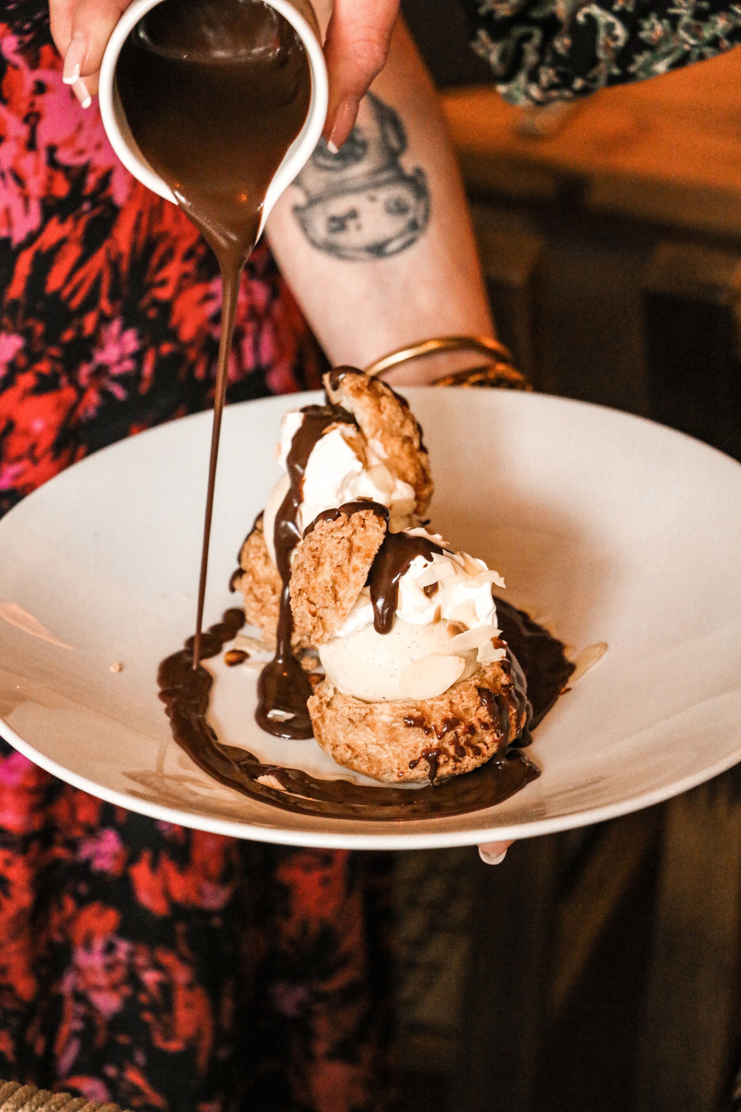 A dessert with chocolate sauce being poured over it.