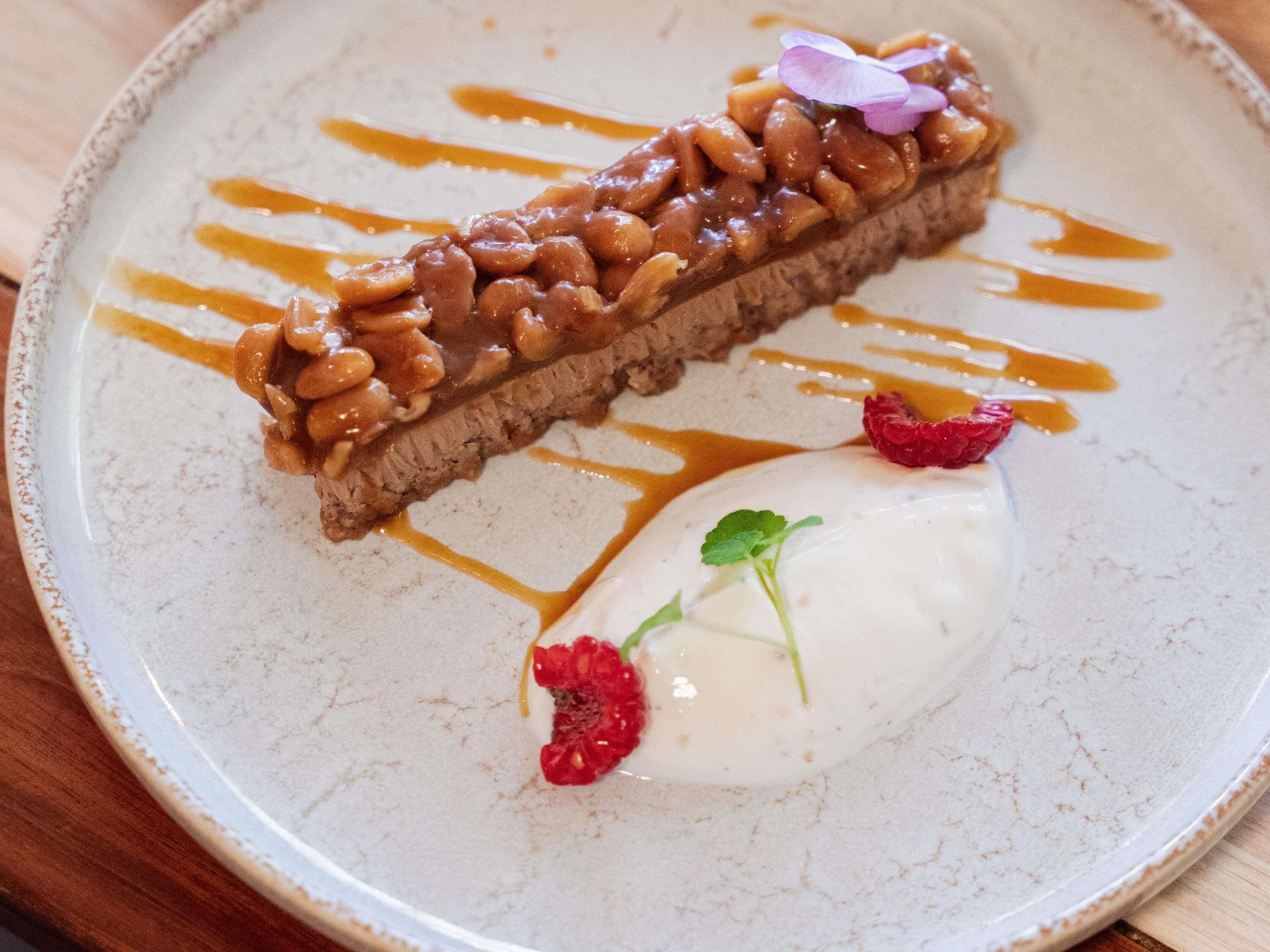 A dessert plate with a pastry, sauce, and a dollop of cream with berries.