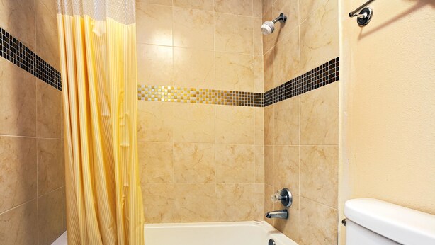 A bathroom with a bathtub, shower, and toilet. - Super 8 by Wyndham Terrell (Terrell)