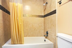 A bathroom with a bathtub, shower, and toilet. - Super 8 by Wyndham Terrell (Terrell)