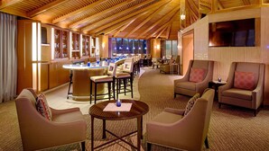 Un vaste espace de détente doté d’un haut plafond, d’un bar avec des tabourets et de sièges confortables.