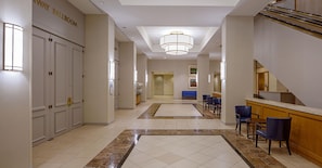 A hotel lobby with a reception desk, seating area, and a staircase. - DoubleTree by Hilton Hotel Houston - Greenway Plaza (Houston)