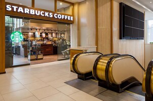Una caffetteria Starbucks con un tapis roulant che porta all'ingresso.