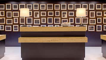 A reception desk with framed artwork on the wall behind it.