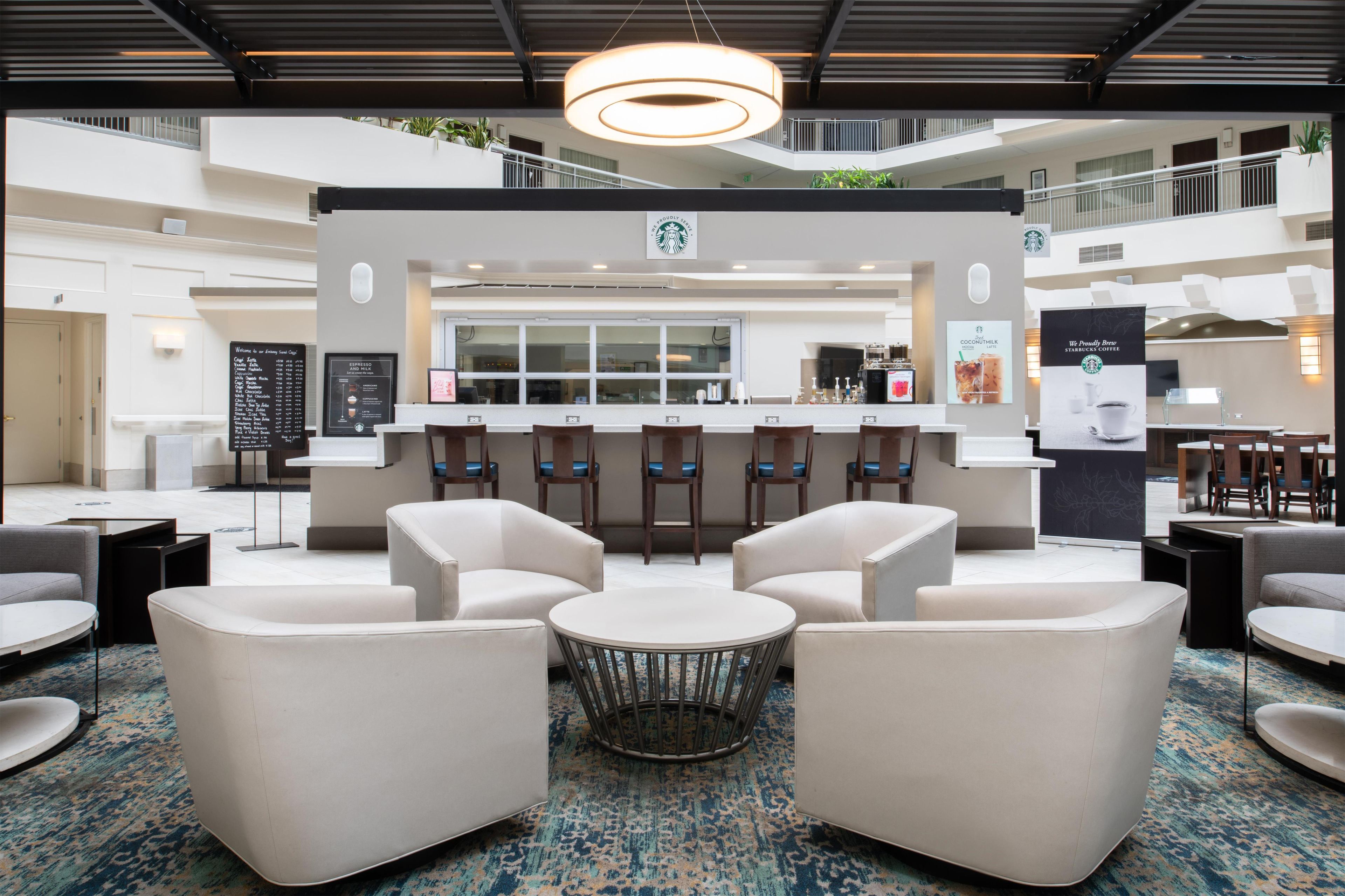 A modern Starbucks coffee shop with seating and a counter.