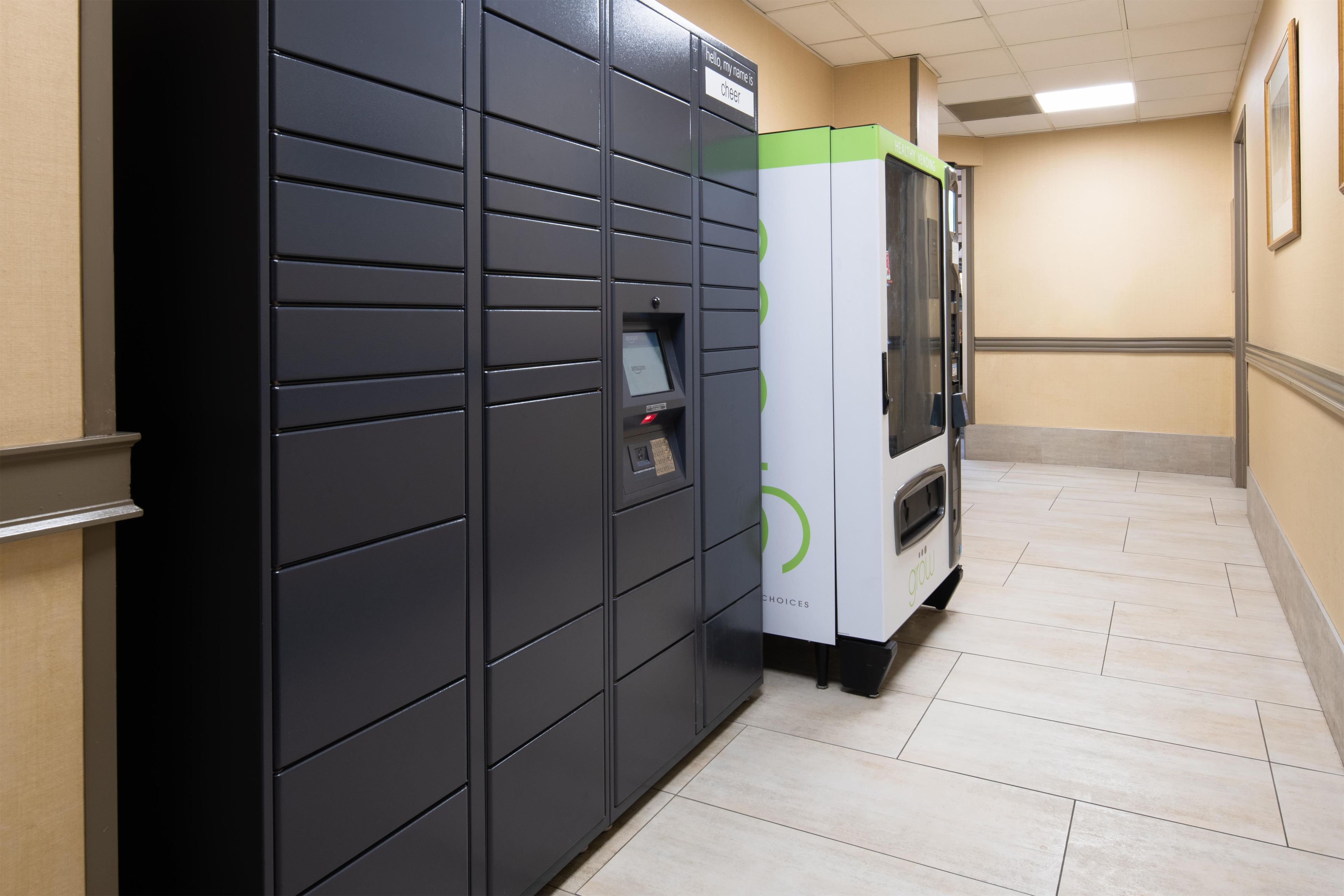 A hallway with lockers and a vending machine.
