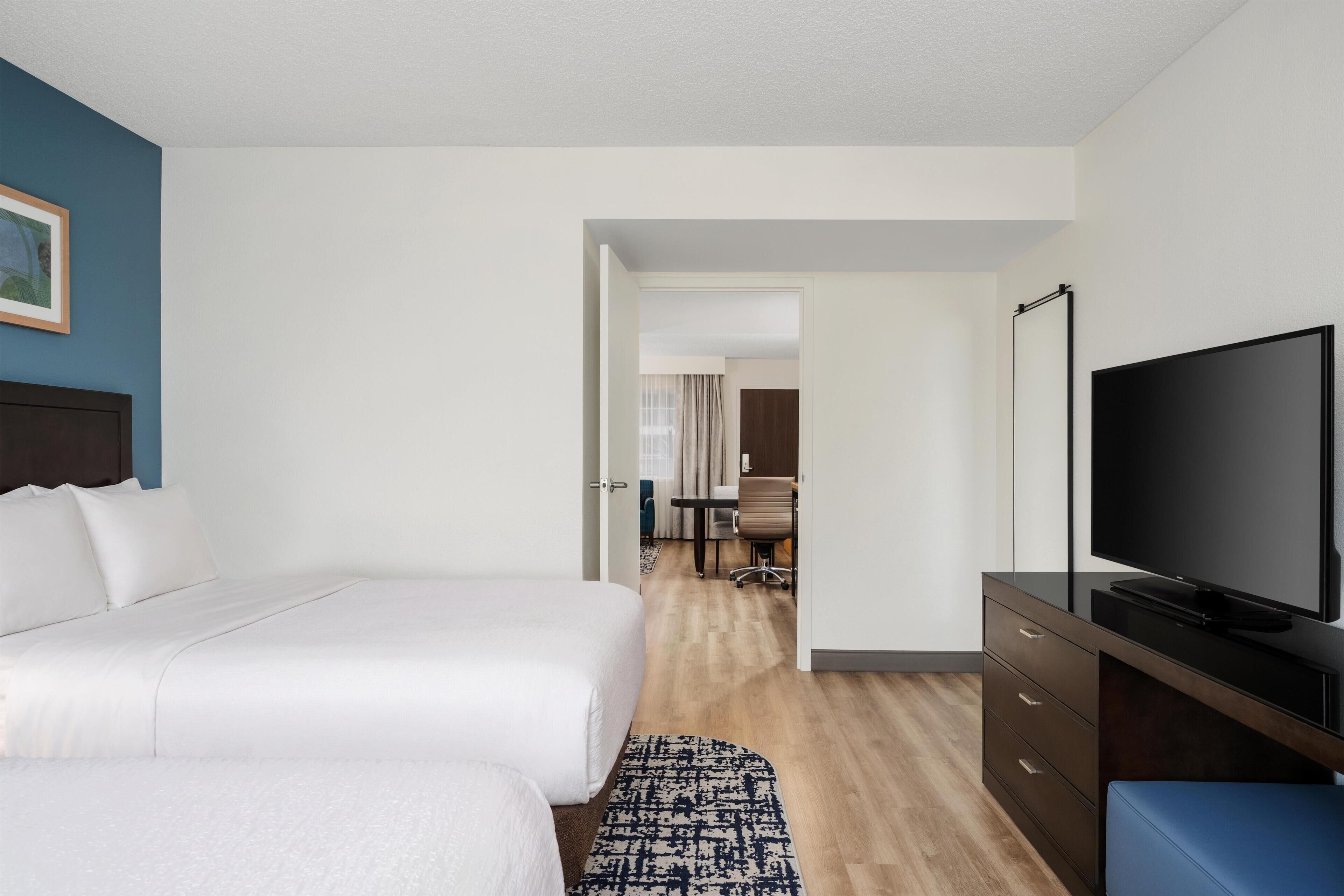 Une chambre d’hôtel équipée d’un lit, d’une télévision, d’un bureau et d’une chaise.