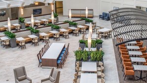Een ruime eetruimte met diverse zithoeken, waaronder zitjes en tafels, en een bar in het midden.