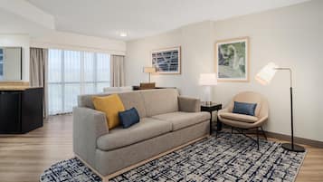 A modern living room with a sofa, armchair, and a patterned rug.