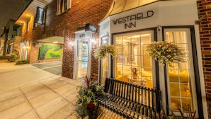 Un hôtel Westfield Inn avec une façade en briques, une entrée bien visible et un banc à l’extérieur.