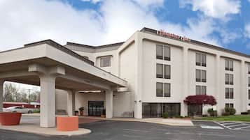 A Hampton Inn hotel with a modern facade, a covered entrance, and a parking lot.