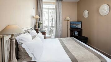 Une chambre d’hôtel avec un grand lit, une télévision, un bureau avec une lampe et une vue sur l’extérieur.
