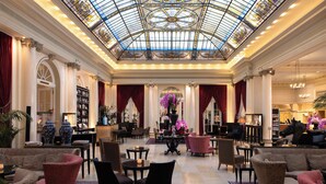 A grand lobby with a high ceiling, ornate columns, and a glass dome.