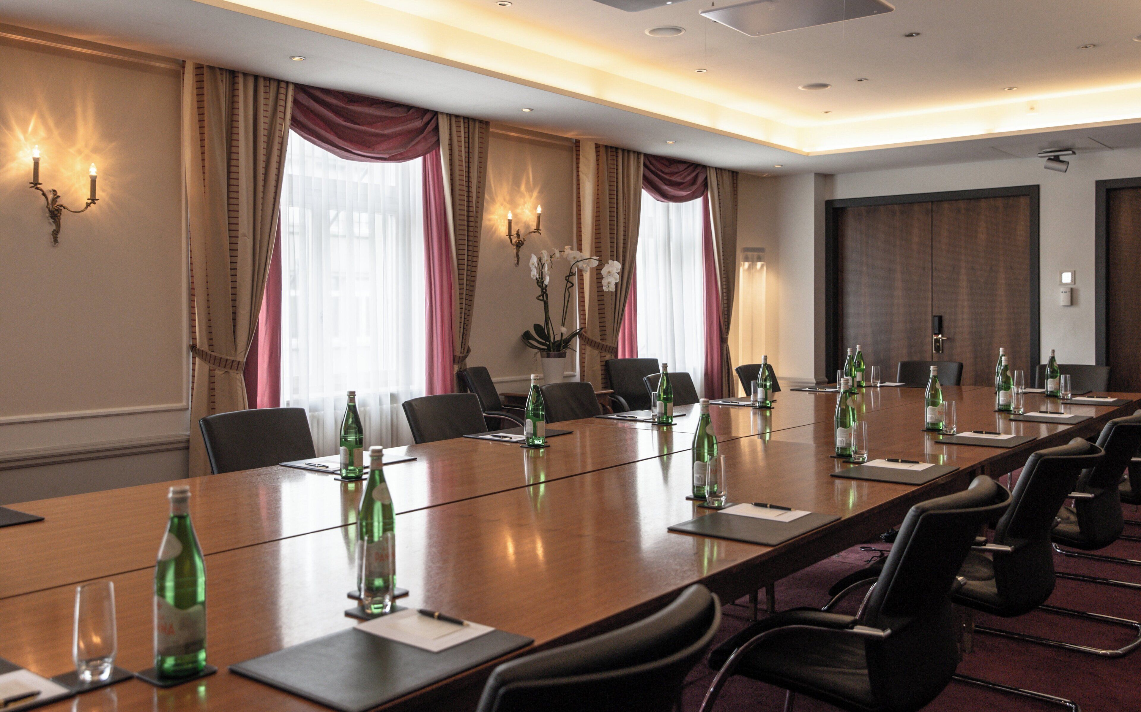 A conference room with a long table, chairs, and water bottles.