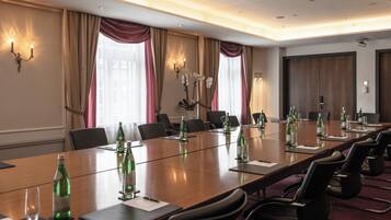 A conference room with a long table, chairs, and water bottles.