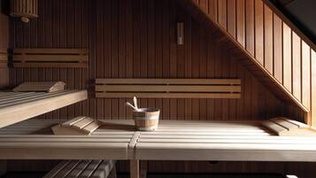 Un sauna avec des bancs en bois et un seau.
