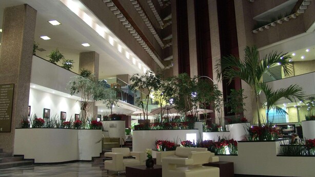 A spacious lobby with a high ceiling, multiple seating areas, and indoor plants. - Radisson Paraiso Hotel Mexico City (Mexico City)