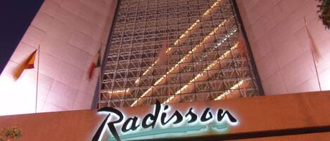 Un edificio con un letrero grande que dice "Radisson" en la entrada.