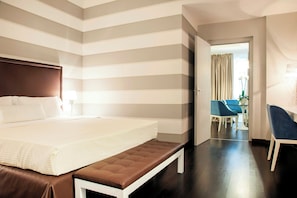 A hotel room with a large bed, a bench, a desk, and a chair. - Sina De la Ville (Milan)