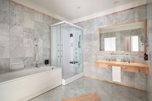 A modern bathroom with a glass-enclosed shower, a white bathtub, and a vanity with a mirror and sink.