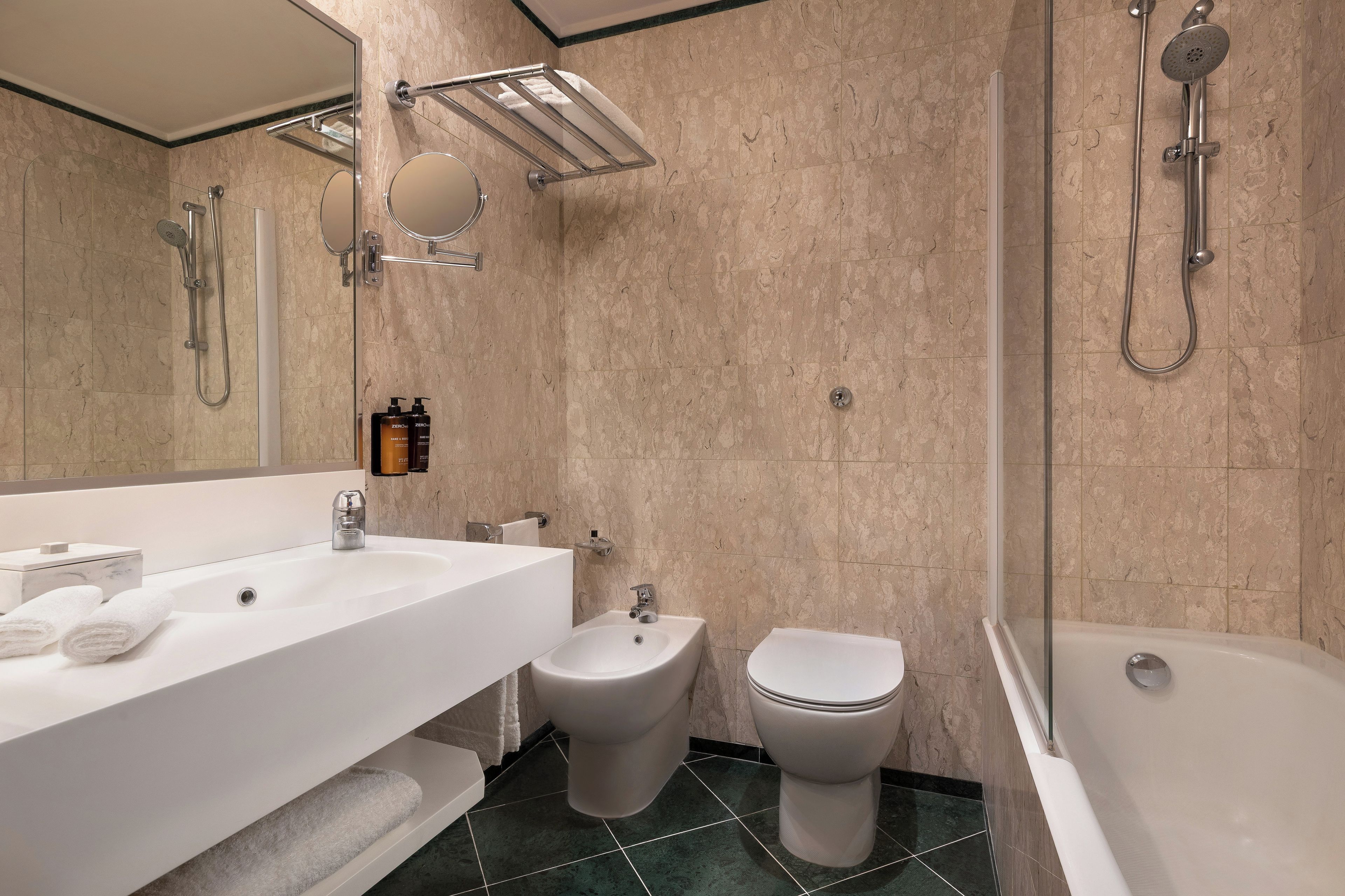 Un baño moderno con un lavamanos grande, bidé, inodoro y bañera.