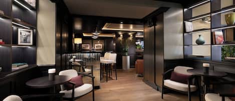 A modern interior with a bar area, seating, and a view into the kitchen.