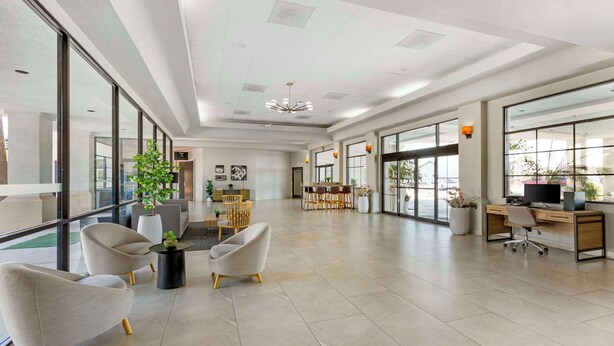 A spacious, well-lit office with modern furniture, large windows, and a clean, minimalist design.