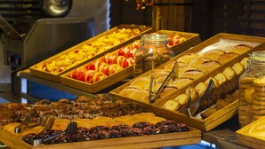 A buffet with various baked goods and pastries.