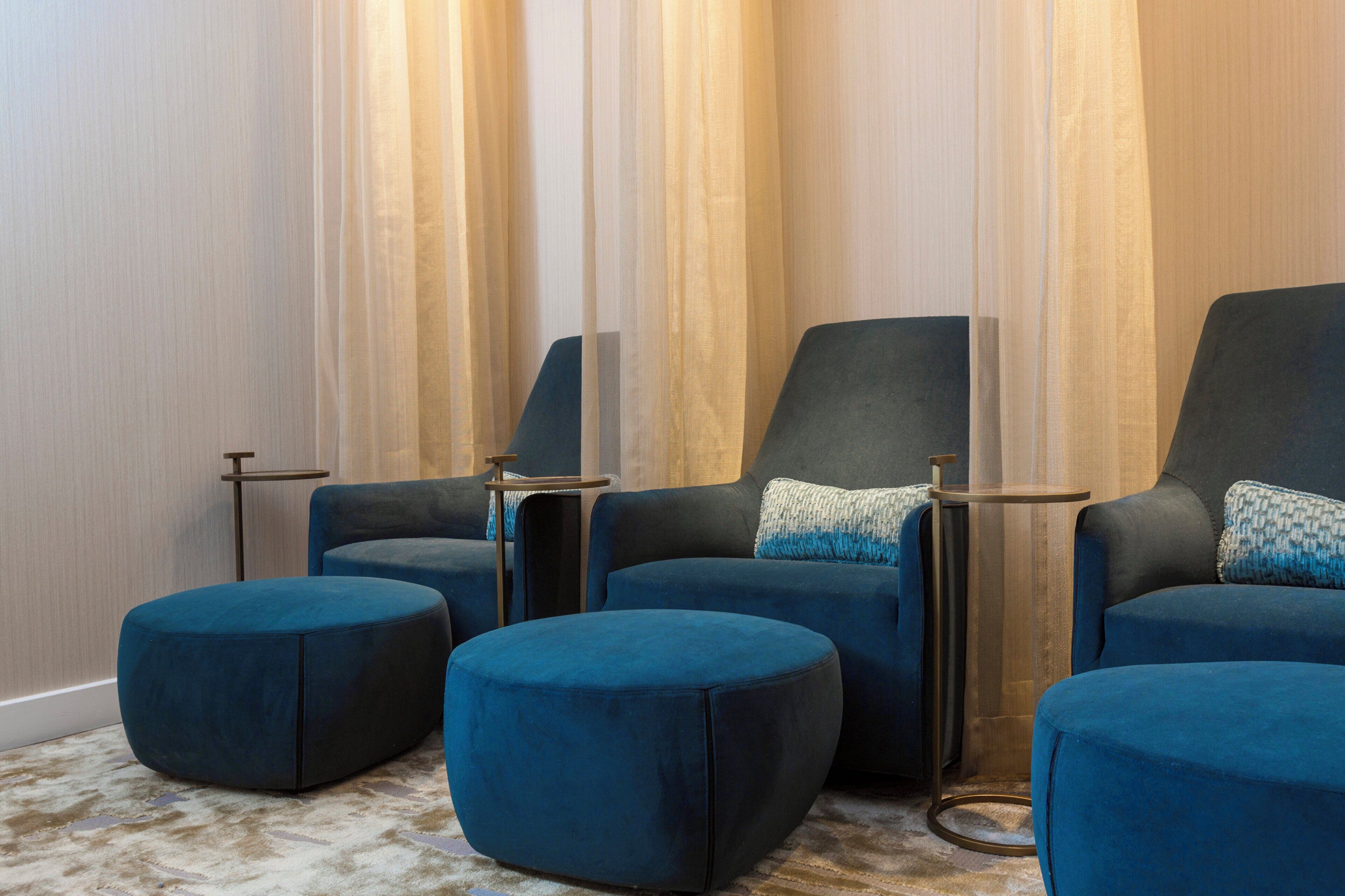 A modern room with a large sectional sofa, two ottomans, and a small side table.