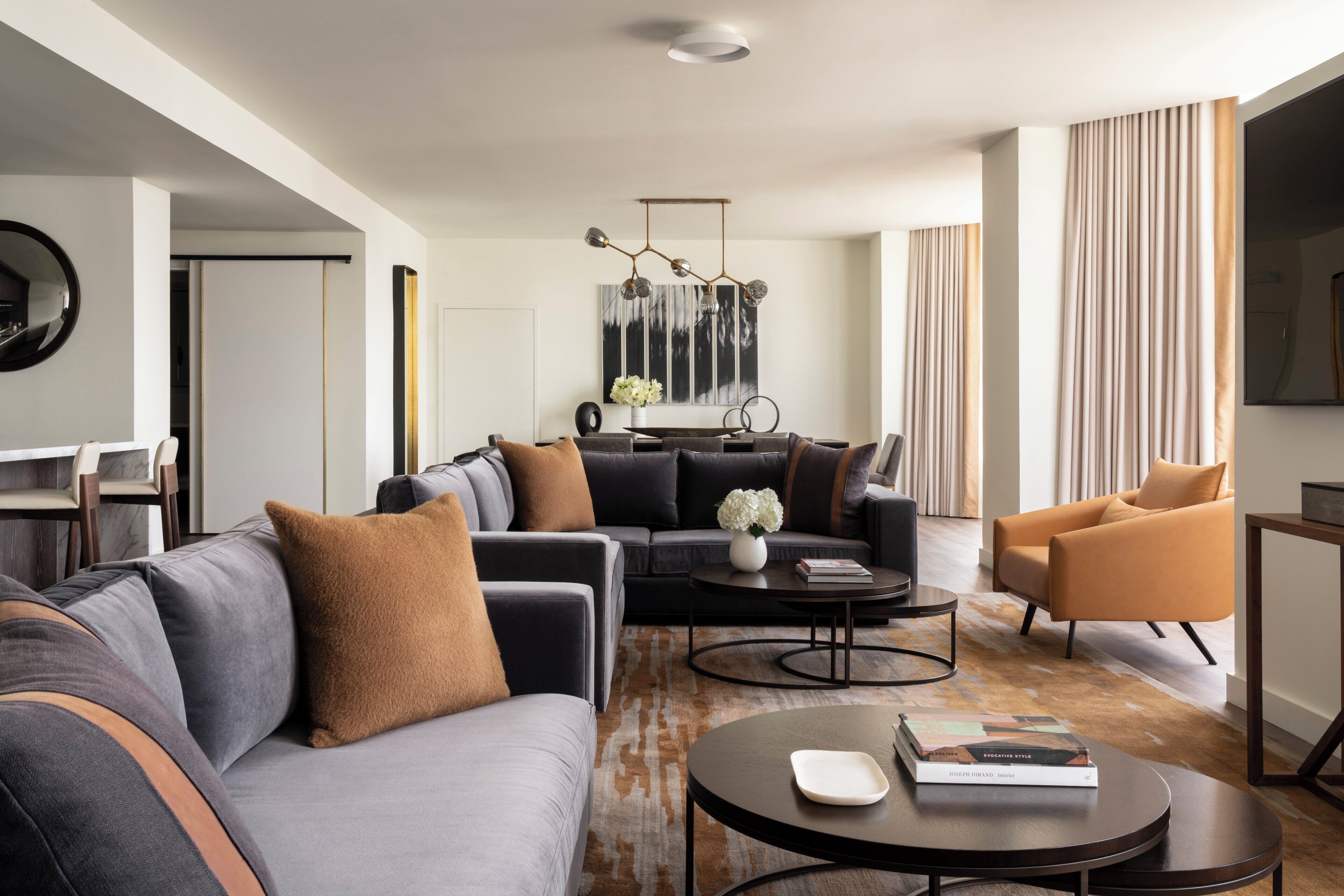 Una sala de estar moderna con un sofá modular, una mesa de centro y un televisor sobre un mueble bajo.