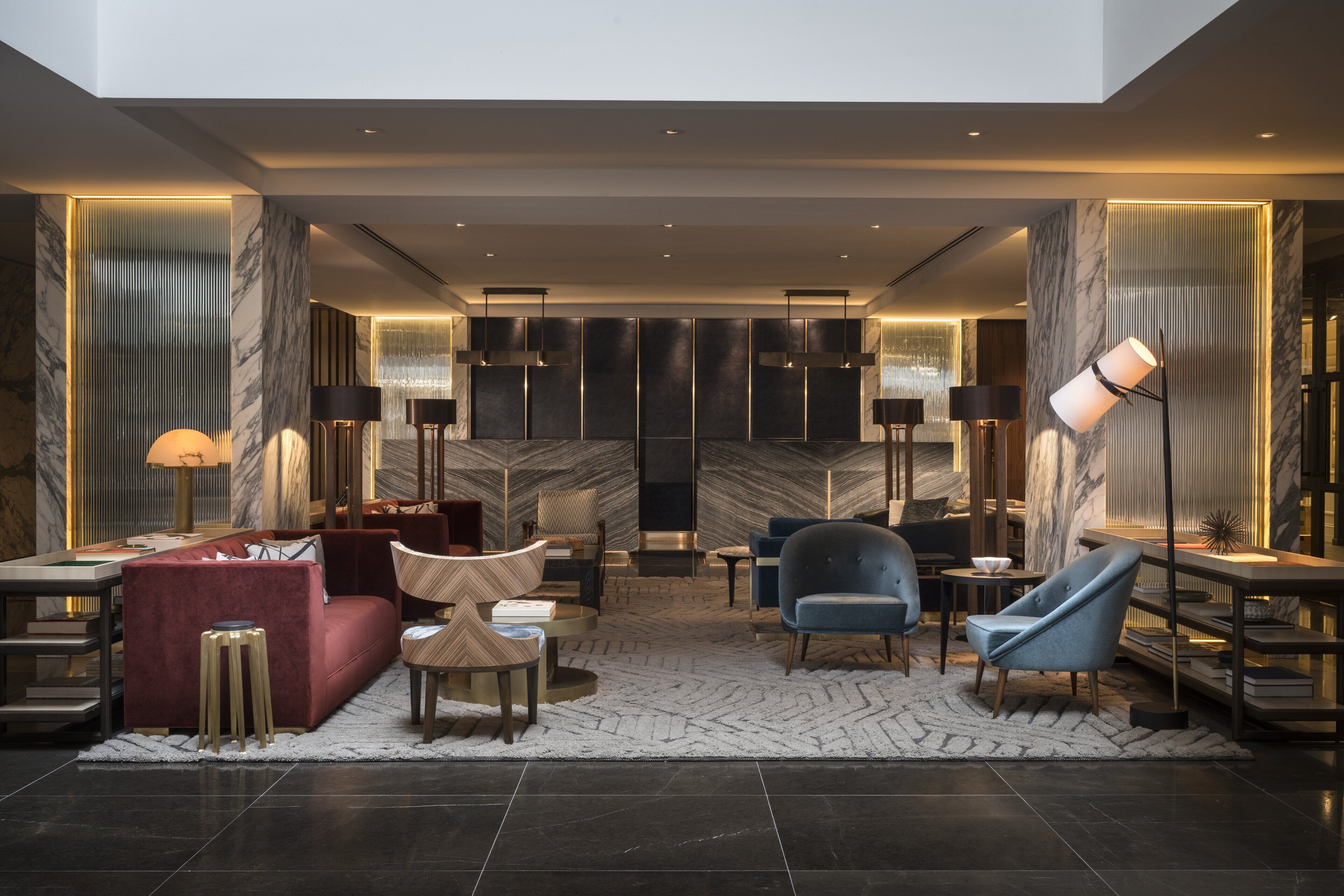 A modern lobby with a marble reception desk, plush seating, and contemporary lighting fixtures.