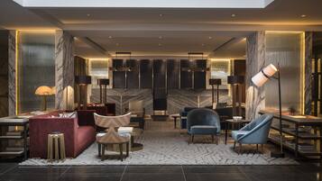 A modern lobby with a marble reception desk, plush seating, and contemporary lighting fixtures.