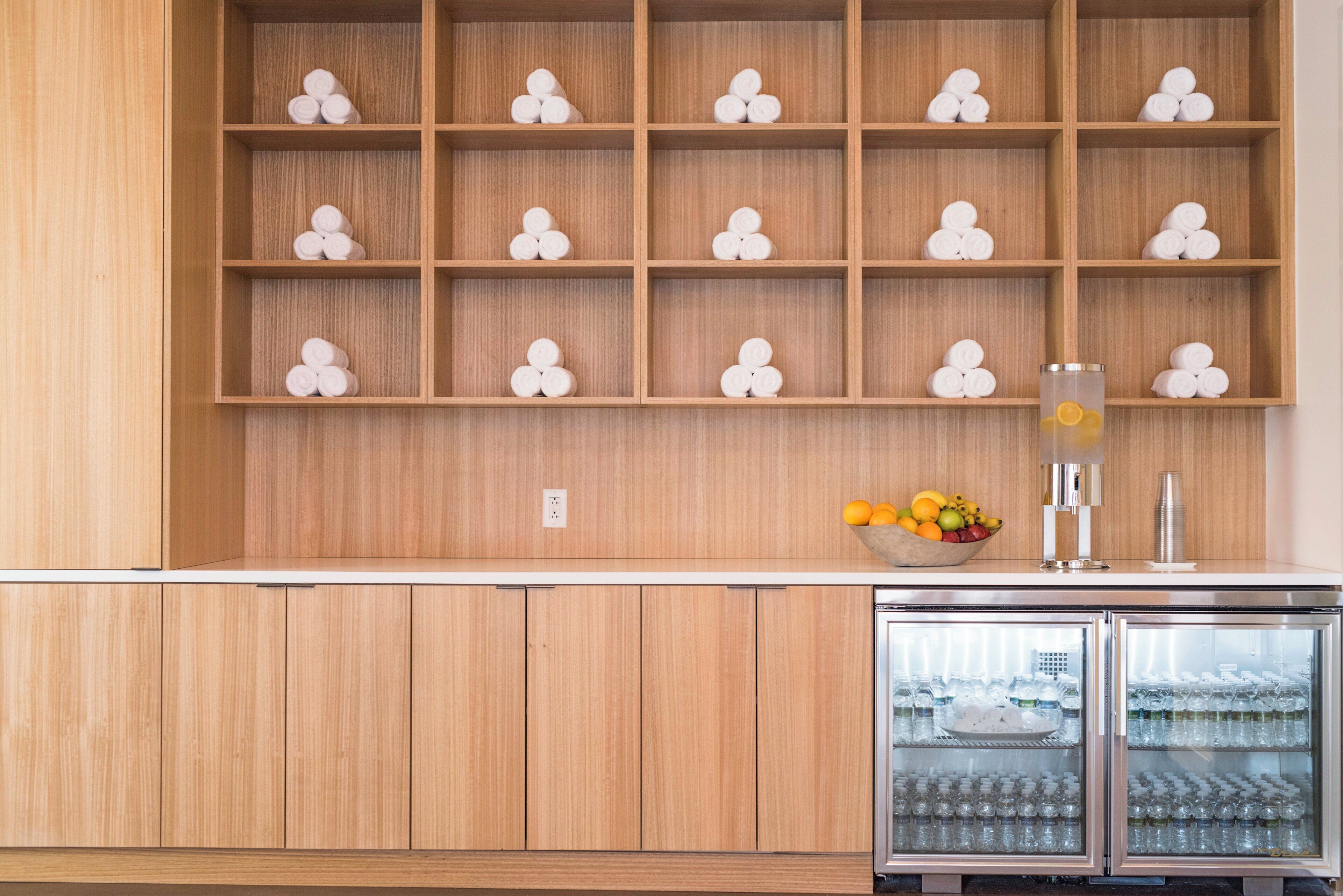 A kitchen with wooden cabinets, a fruit bowl, and a refrigerator.