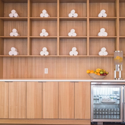 A kitchen with wooden cabinets, a fruit bowl, and a refrigerator.