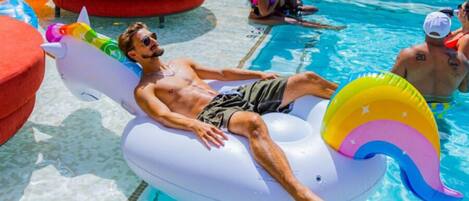 A man lying on a colorful inflatable float in a pool.