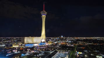 A night view of a cityscape with a prominent tower and a casino complex.