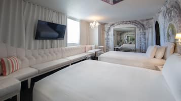 Una habitación de hotel con una cama grande, un sofá, un televisor y un espejo.