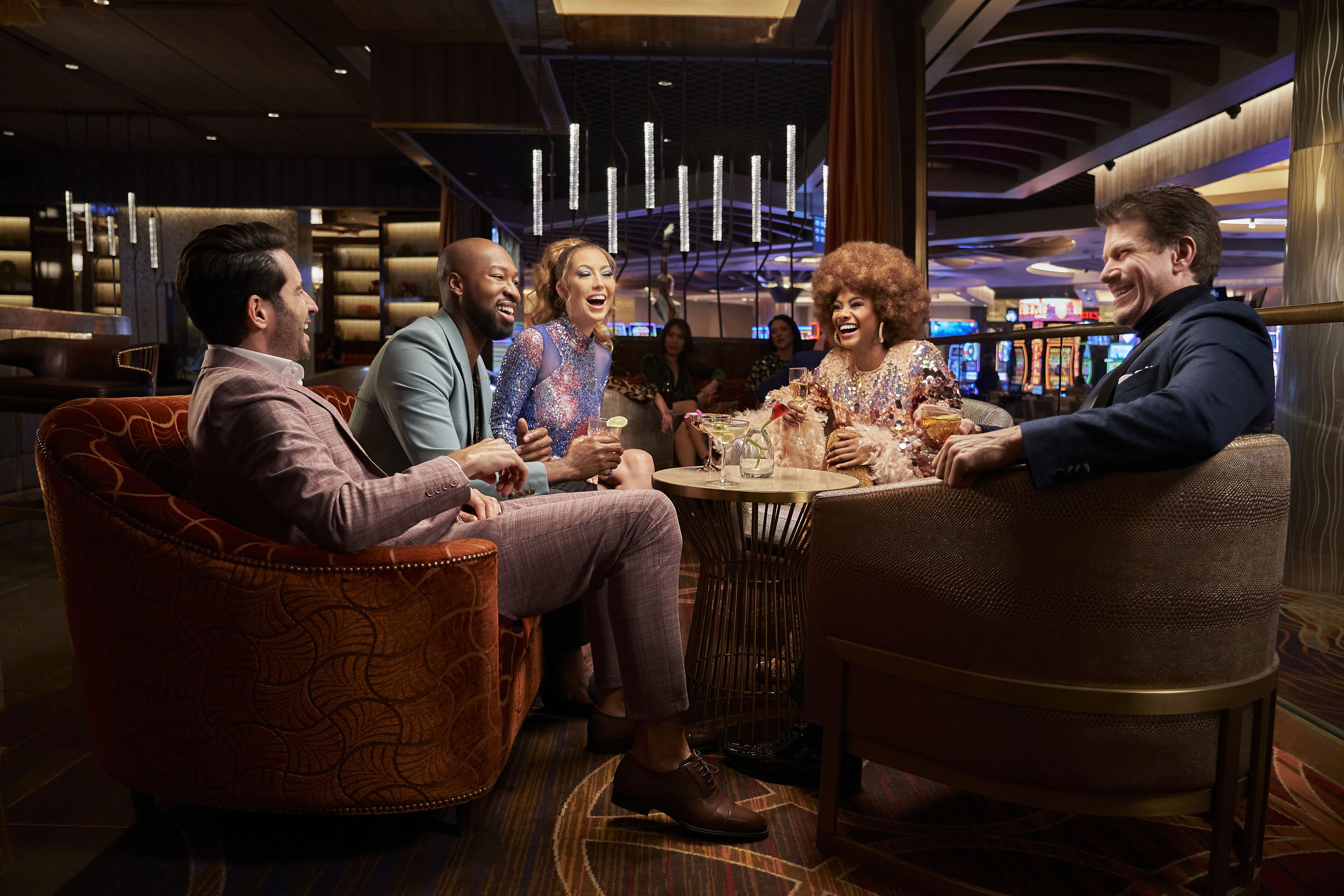 A group of people seated around a round table in a well-lit indoor setting with modern decor and ambient lighting.