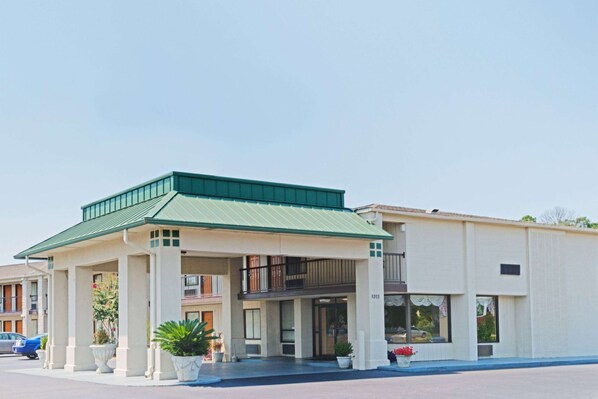 A hotel with a green awning, a covered entrance, and a number "1013" on the building. - Baymont by Wyndham Troy (Troy)